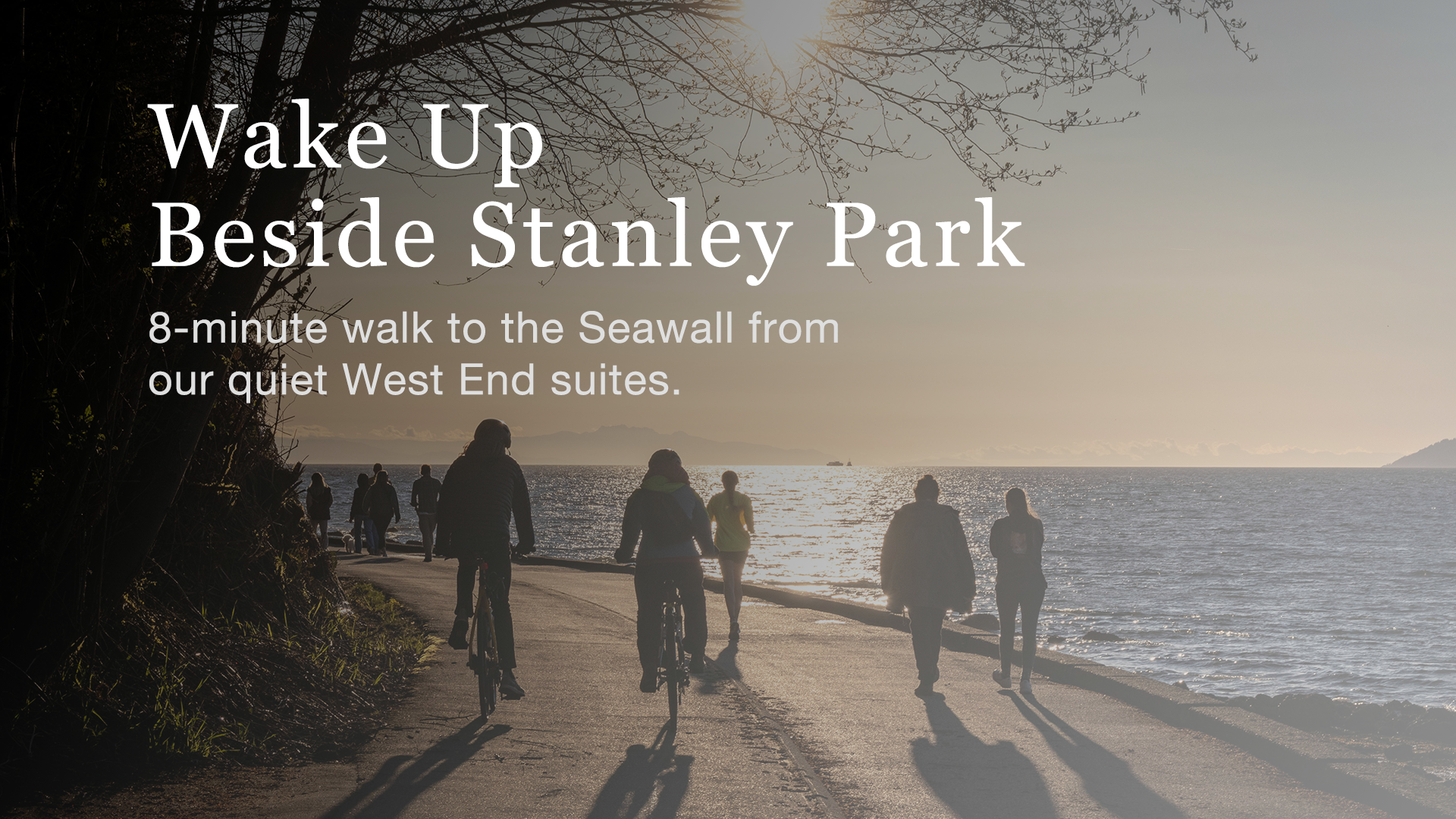 People walking and cycling along the Stanley Park Seawall in Vancouver’s West End at sunset