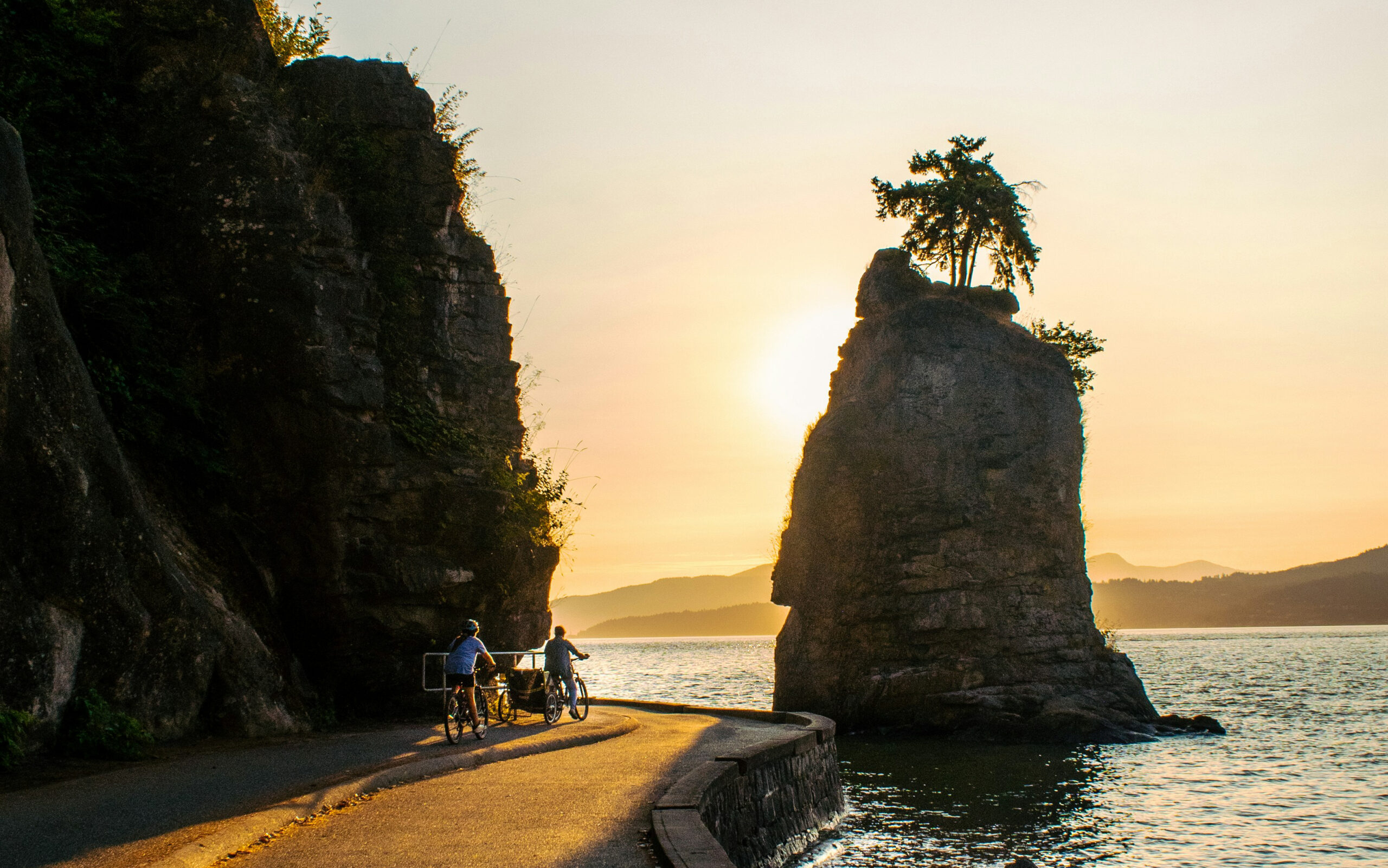Cyclists on the Stanley Park Seawall near Siwash Rock Vancouver