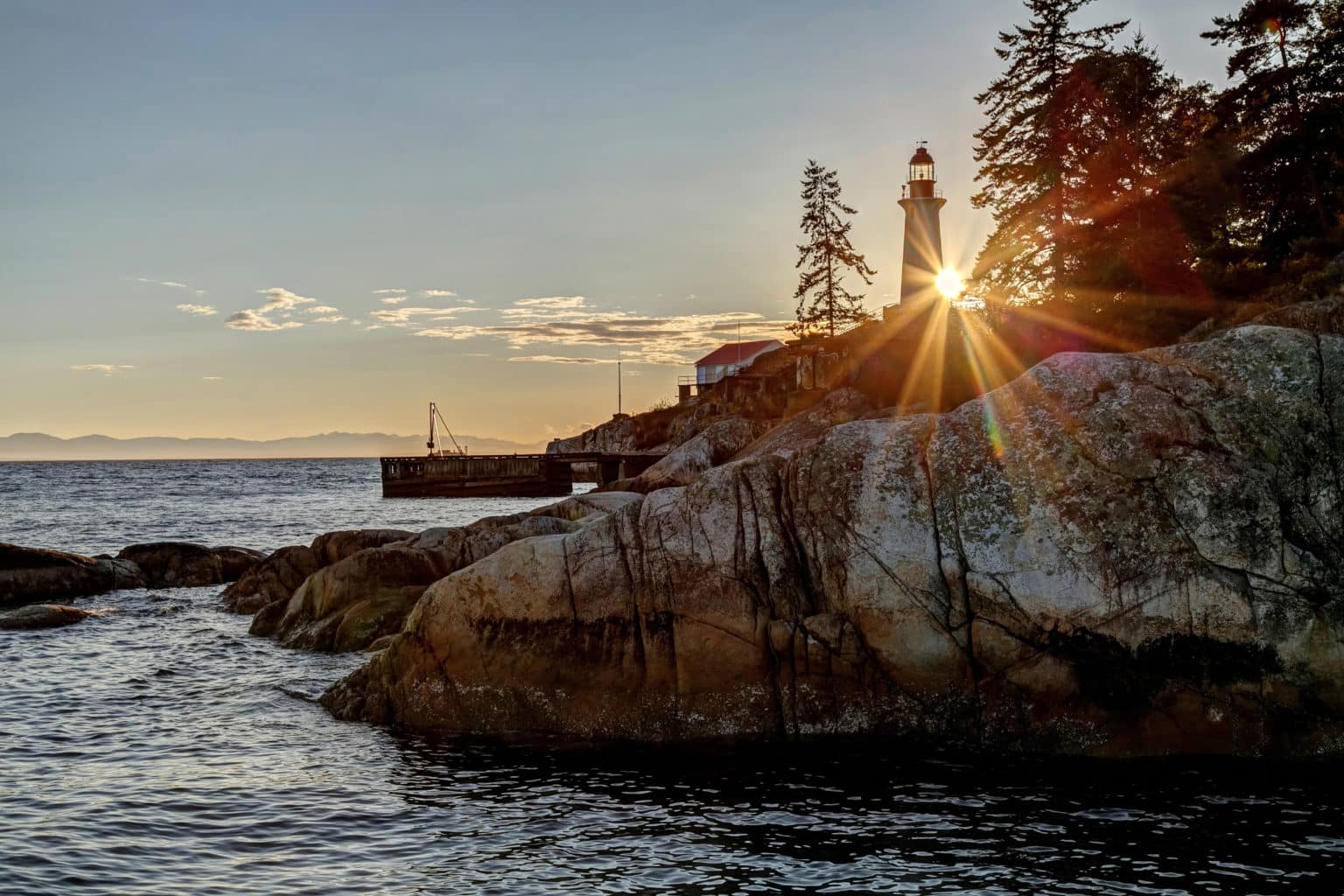 Point Atkinson Lighthouse and rocky shoreline at sunset in Lighthouse Park, West Vancouver